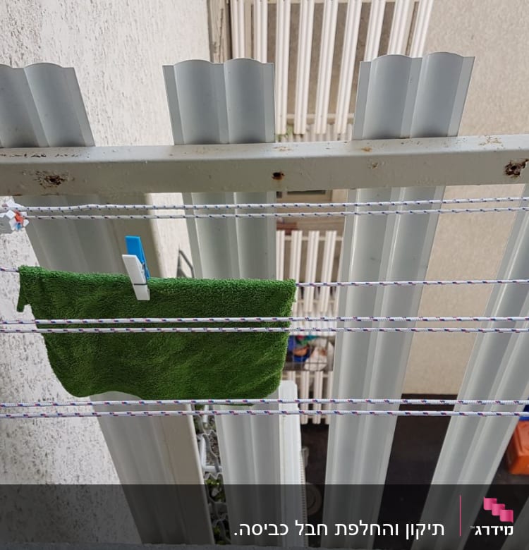 חבלים לתליית כביסה עם אטבים ומגבת ירוקה